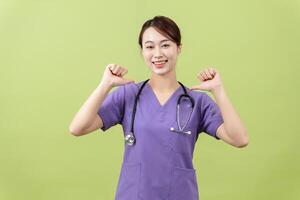 Photo of young Asian femle doctor on green background