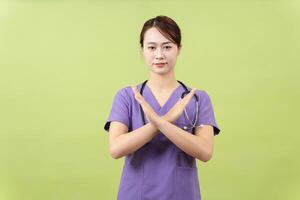 Photo of young Asian femle doctor on green background