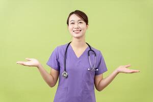 Photo of young Asian femle doctor on green background