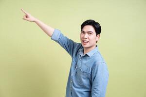 Photo of young Asian man on green background