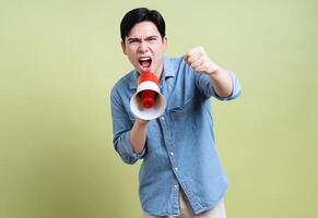 Photo of young Asian man on green background