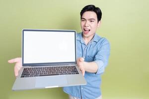 Photo of young Asian man on green background