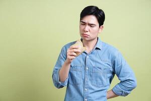 Photo of young Asian man on green background