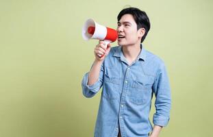 Photo of young Asian man on green background