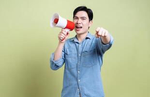 Photo of young Asian man on green background