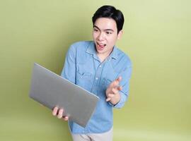 Photo of young Asian man on green background