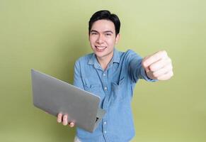 Photo of young Asian man on green background