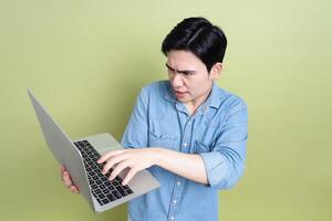 Photo of young Asian man on green background