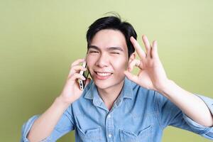 Photo of young Asian man on green background