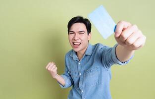 Photo of young Asian man on green background