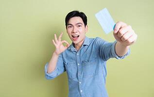 Photo of young Asian man on green background