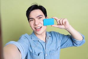 Photo of young Asian man on green background