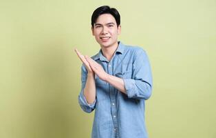 Photo of young Asian man on green background