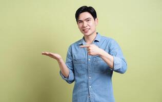 Photo of young Asian man on green background
