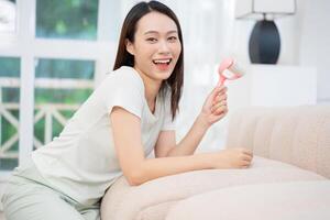 Young Asian woman cleaning sofa photo