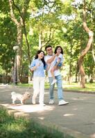 Photo of young Asian family at park