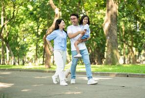 Photo of young Asian family at park