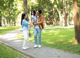 Photo of young Asian family at park