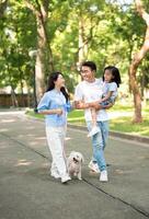 Photo of young Asian family at park