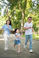 Photo of young Asian family at park