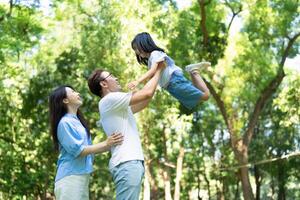 Photo of young Asian family at park