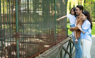 Photo of young Asian family at park