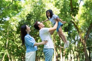 Photo of young Asian family at park