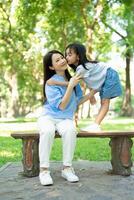 Photo of Asian mother and daughter at park