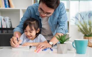 Photo of Asian father and daughter studying at home