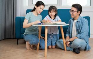 Photo of young Asian family studying together at home