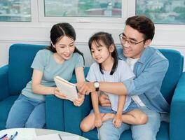 Photo of young Asian family studying together at home