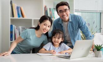 Photo of young Asian family studying together at home