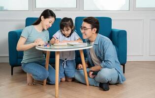 Photo of young Asian family studying together at home