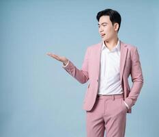 Photo of young Asian businessman wearing pink suit on background