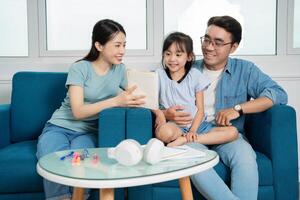 Photo of young Asian family studying together at home