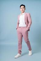 Photo of young Asian businessman wearing pink suit on background