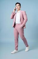 Photo of young Asian businessman wearing pink suit on background