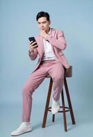 Photo of young Asian businessman wearing pink suit on background