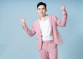 Photo of young Asian businessman wearing pink suit on background