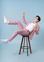 Photo of young Asian businessman wearing pink suit on background