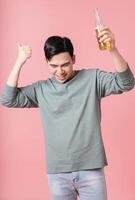Photo of young Asian man drinking alcohol on background