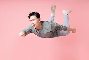 Photo of young Asian man flying on background