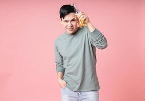 Photo of young Asian man drinking alcohol on background