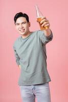 Photo of young Asian man drinking alcohol on background