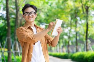 Portrait of young Asian man outside photo