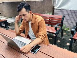 Portrait of young Asian man outside photo