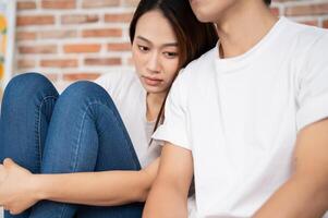 Photo of young Asian couple at home