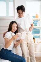 Photo of young Asian couple at home