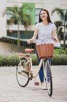 Photo of young Asian woman with bicycle