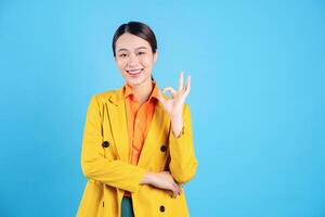 Photo of young Asian businesswoman with colorful suit on background